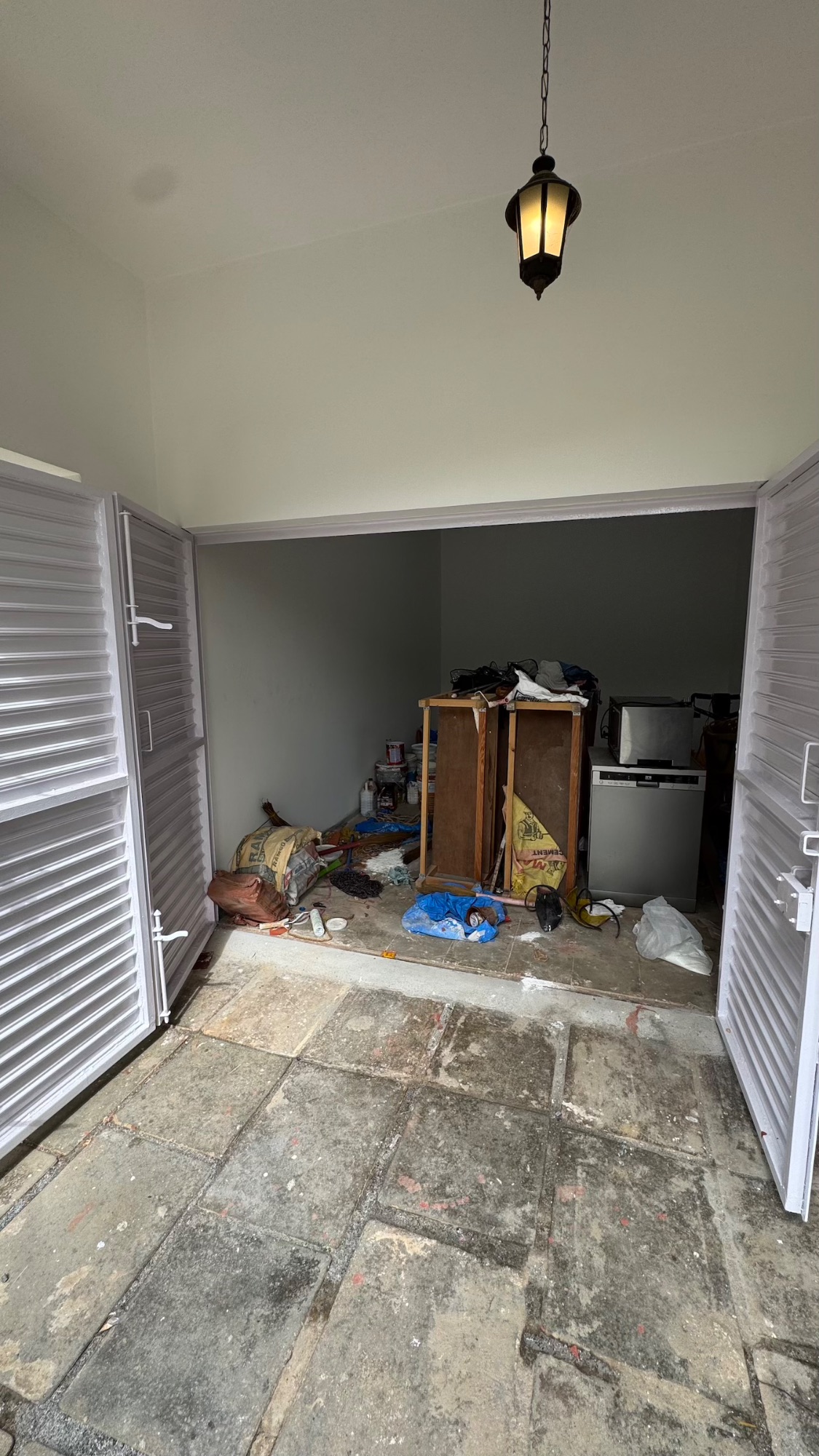 Inside the garage, doors open, the owner's things still stacked at the back.
