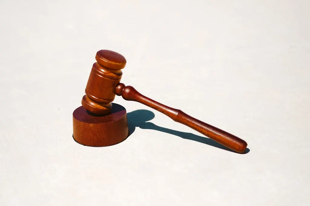 A wooden gavel resting on a pale surface.