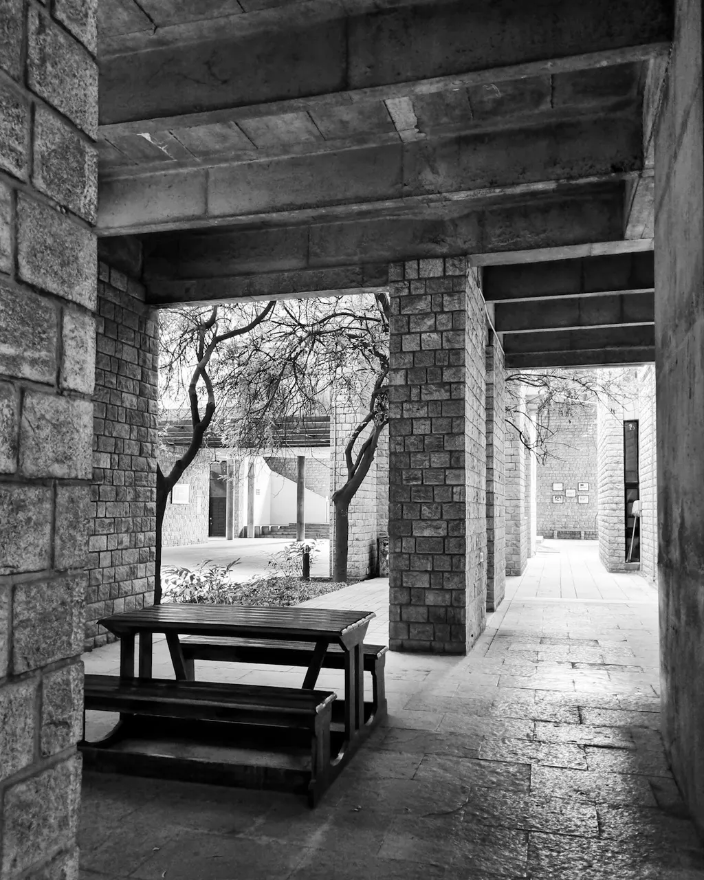 A bench and table, photographed in black and white