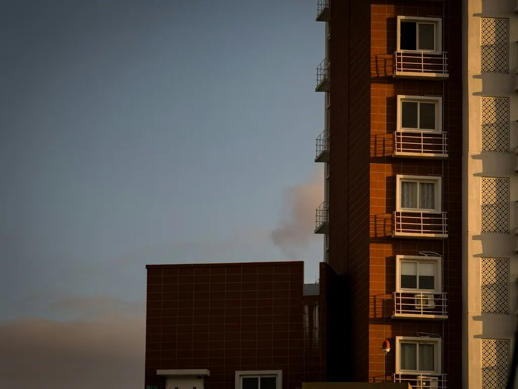 A tall apartment block, balcony above balcony